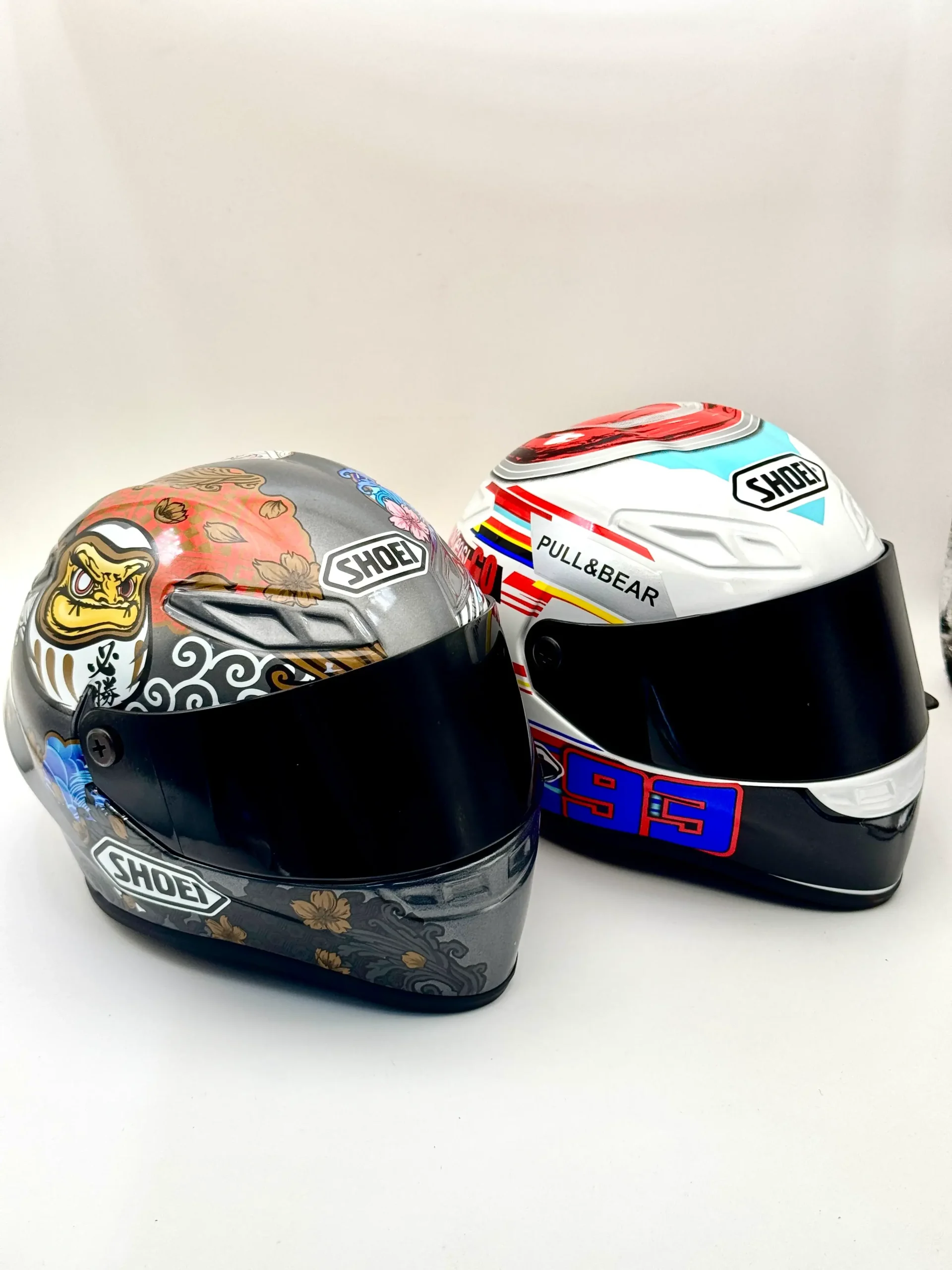 Two full-face helmet shells with multicolour surface decoration — curved component sample