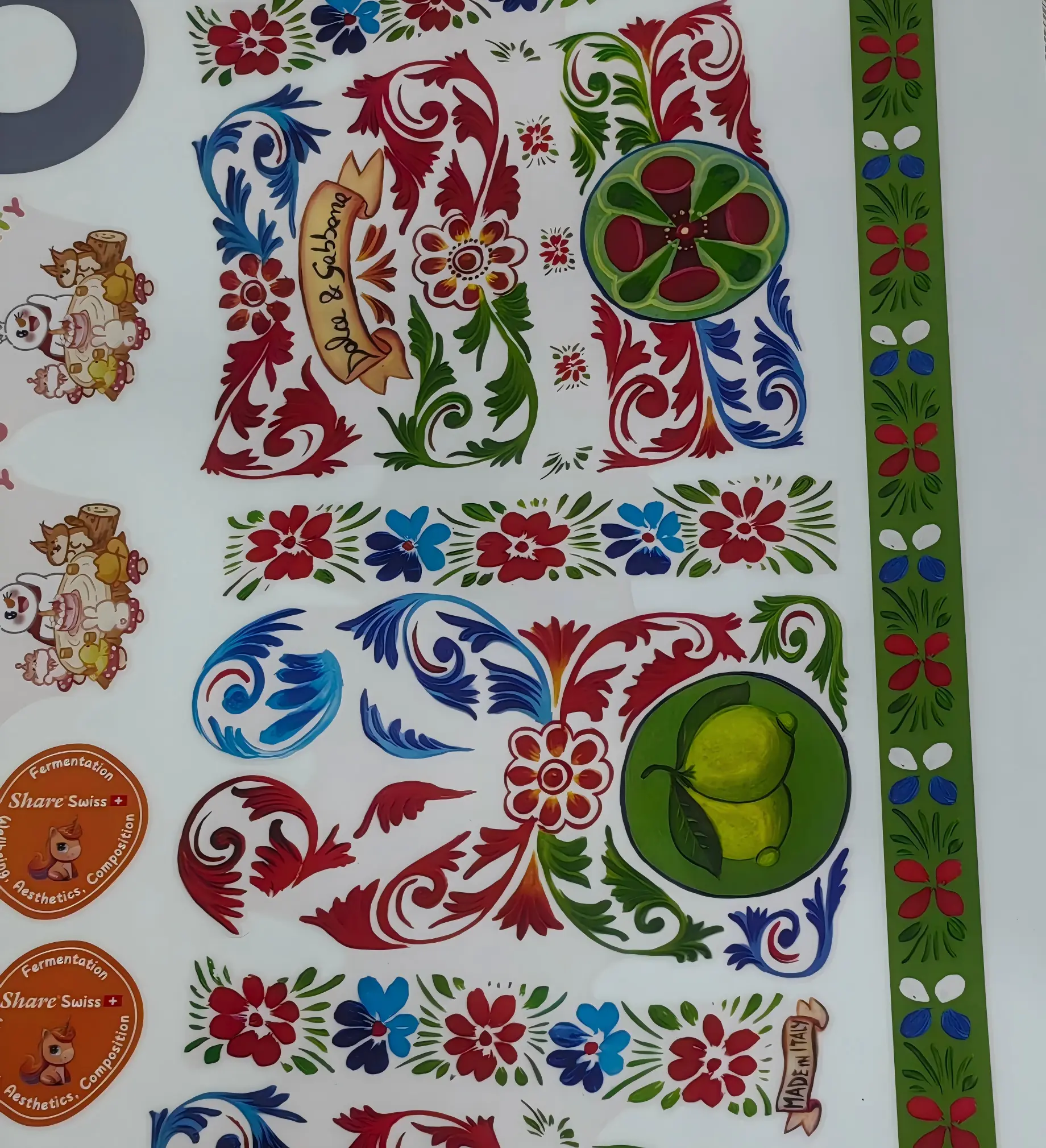 Printed waterslide decal samples — red, blue and green decorative patterns with fruit and flower motifs on white backing paper