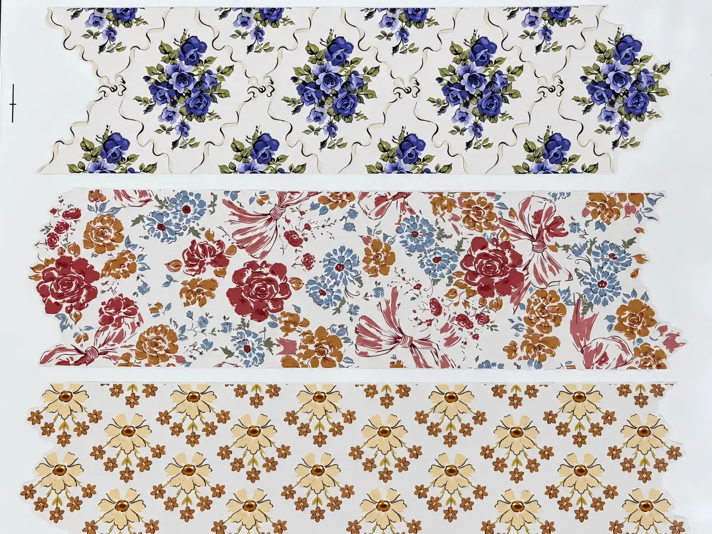 Printed waterslide decal samples — three floral strips with purple roses, vintage flowers and yellow daisies on white backing paper