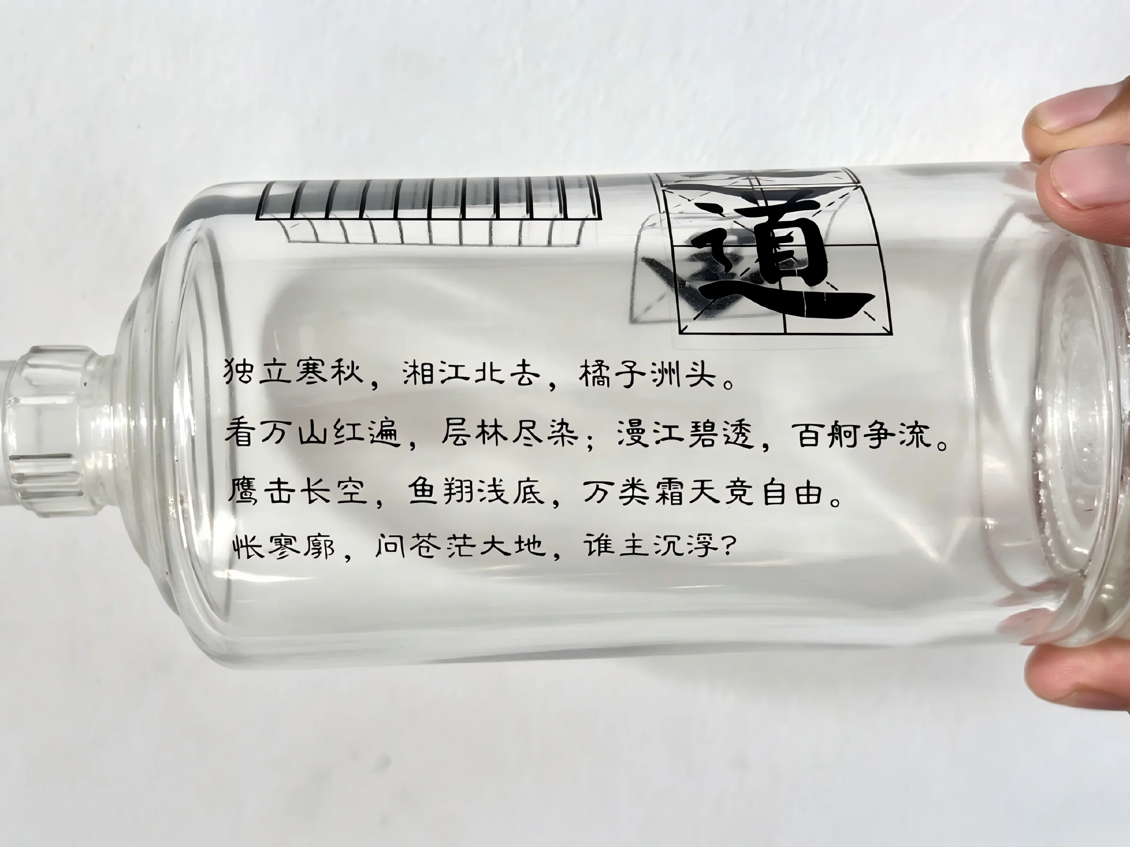 Clear glass bottle with black printed text and graphics